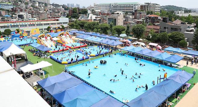 30일 오후 서울 성북구 성북초등학교 운동장에 마련된 물놀이장을 찾은 어린이와 시민들이 물놀이하며 더위를 식히고 있다. 김정효 기자