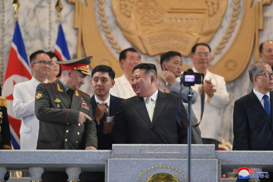 김정은 북한 국무위원장이 ‘전승절’(6ㆍ25전쟁 정전협정기념일) 70주년인 지난 27일 저녁 평양 김일성광장에서 열린 열병식 주석단에서 러시아 대표단 단장인 세르게이 쇼이구 국방부 장관과 얘기하고 있다. 오른쪽은 중국 대표단 단장인 리훙중 전국인민대표대회 상무위원회 부위원장(국회부의장 격). 조선중앙통신 캡처. 연합뉴스