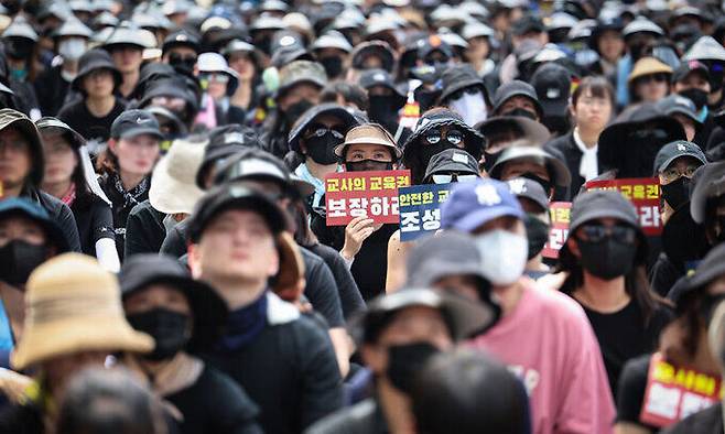 전국 각지에서 모인 교사들이 지난 29일 서울 종로구 경복궁역 사거리 인근에서 열린 공교육 정상화를 위한 집회에 참석해 팻말을 흔들고 있다. 연합뉴스