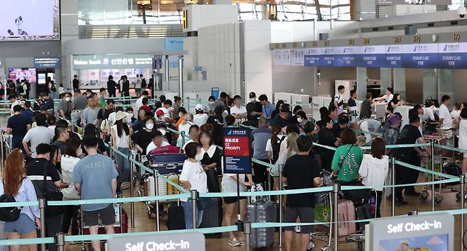 지난 28일 인천국제공항 제1터미널에서 이용객들이 줄을 서고 있다. 인천국제공항공사는 올 여름철 휴가 성수기인 7월25일~8월15일에 인천공항 이용객이 391만8855명, 하루 평균 17만8130명이 될 것으로 전망했다. [사진=연합뉴스]