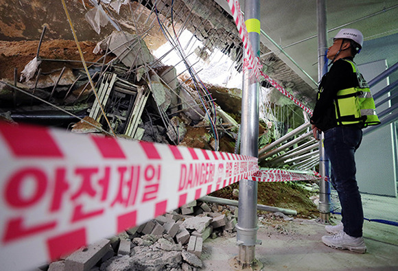 An accident investigator at the Ministry of Land, Infrastructure and Transport is conducting an on-site inspection at an apartment construction site in Geomdan New Town, Incheon, on July 2. A roof structure on the first and second floors of an underground parking lot collapsed here on June 29. [Photo by Yonhap]