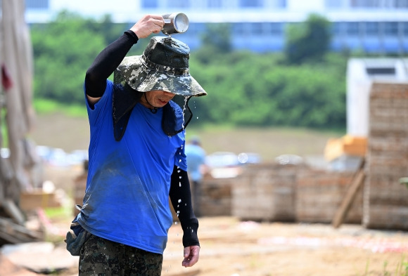 전국 대부분 지역에 폭염특보가 내려진 31일 경기도 과천시의 한 공사현장에서 작업자가 차가운 물을 뿌리며 땀을 식히고 있다. 2023.7.31 오장환 기자