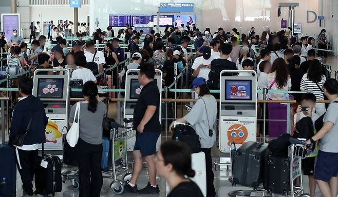 여름 휴가철을 맞은 지난달 30일 오전 인천국제공항 출국장에서 해외로 떠나는 이용객들이 탑승수속을 밟고 있다. 뉴스 1