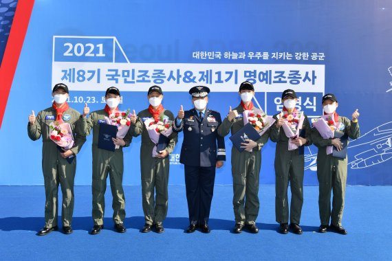 박인호 공군참모총장이 2021년 10월 23일 경기 성남시 서울 ADEX 2021 행사장에서 개최된 ‘제8기 국민조종사 임명식’에서 제8기 국민조종사와 제1기 명예조종사들과 기념촬영 하고 있다. 사진=공군 제공