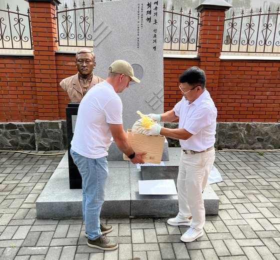 지난 25일 러시아 극동 연해주 우수리스크에 있는 최재형 기념관에서 김 니콜라이 우수리스크 고려인민족문화자치회장(오른쪽)이 독립운동가인 최재형 지사의 부부합장묘 복원에 사용할 흙을 채취하고 있다.연합뉴스