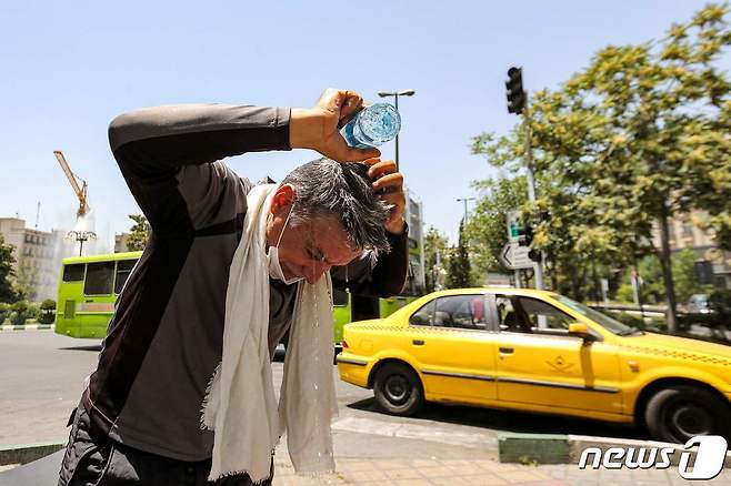 이란의 한 시민이 머리에 물을 끼얹고 있다.  ⓒ AFP=뉴스1