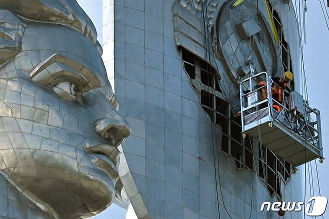 1일(현지시간) 우크라이나 수도 키이우에서 작업자들이 전쟁 박물관에 설치된 '조국 기념비'에서 구 소련의 상징물인 낫과 방패를 철거하고 있다. 2023.8.1. ⓒ AFP=뉴스1 ⓒ News1 김성식 기자