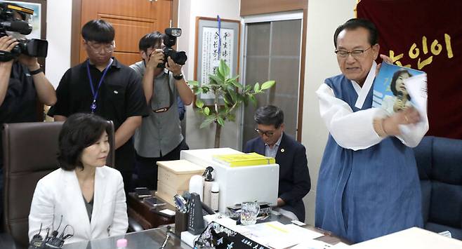 김호일 대한노인회 회장이 3일 서울 용산 대한노인회 중앙회에서 노인폄하 발언 사과를 위해 방문한 더불어민주당 김은경 혁신위원장과 면담 중 김 위원장의 얼굴 사진을 때리고 있다. 연합뉴스