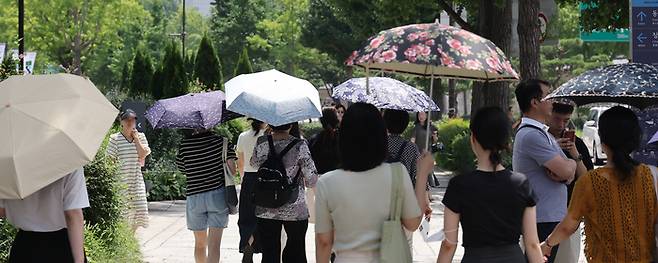 무더위가 계속된 3일 서울 종로구 삼청동길에서 시민들이 강한 햇살에 양산을 쓰고 이동하고 있다. 연합뉴스