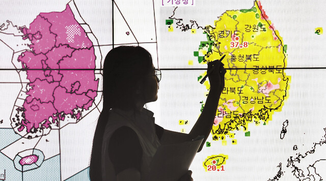 경기도 여주 금사면의 일 최고기온이 38.8도까지 치솟는 등 전국 무더위가 계속된 2일 수원 권선구 수도권기상청에서 예보관이 폭염 지도를 가리키고 있다. 이날 167곳에는 이틀 이상 일 최고 체감온도가 35도 이상 예상될 때 발령하는 폭염경보가 내려졌다. 연합뉴스