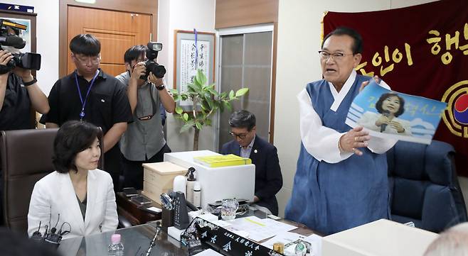 3일 용산 대한노인회 중앙회에서 김호일 회장이 노인폄하 발언 사과를 위해 방문한 더불어민주당 김은경 혁신위원장과 면담 중 위원장의 뺨 대신 사진을 때리고 있다. [연합]