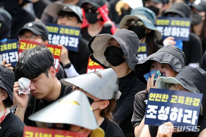 [서울=뉴시스] 조성우 기자 = 지난달 29일 오후 서울 종로구 정부서울청사 앞에서 열린 서이초 교사 추모 및 공교육 정상화 촉구 집회에서 한 참가자가 추모 영상을 보다 눈물을 흘리고 있다. 2023.08.03. xconfind@newsis.com