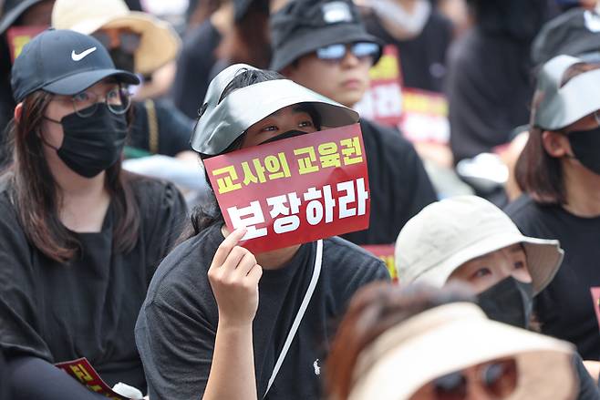 전국 각지에서 모인 교사들이 지난달 29일 서울 종로구 경복궁역 사거리 인근에서 열린 공교육 정상화를 위한 집회에서 팻말을 들고 있다. 연합뉴스