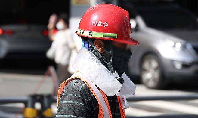 지난 4일 대구 중구의 한 공사장에서 근로자가 목에 얼음 주머니를 두르고 더위를 이겨내고 있다. 연합뉴스