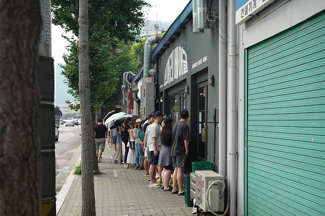 A long line forms in front of Kokkili Bagel in Yeongdeungpo-gu, western Seoul on July 29. (Lee Si-jin/The Korea Herald)