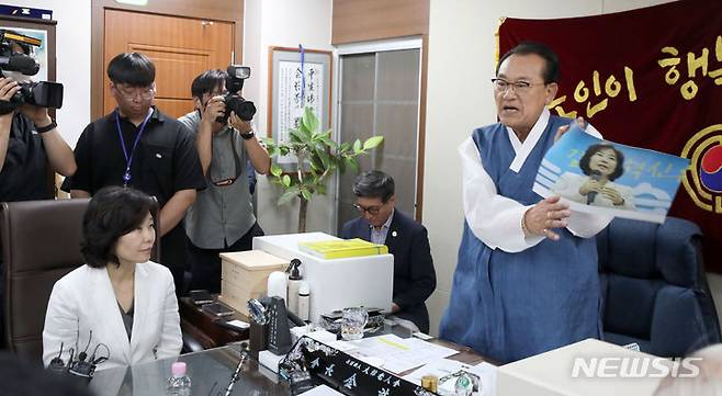 [서울=뉴시스] 김선웅 기자 = 김호일 대한노인회장이 3일 서울 용산구 대한노인회 중앙회에서 노인 비하 발언 논란으로 사과 방문한 김은경 더불어민주당 혁신위원장에게 사과를 받고 면담을 하는 중 김 위원장의 사진을 손으로 때리며 노인 분노를 표현하고 있다 2023.08.03. mangusta@newsis.com