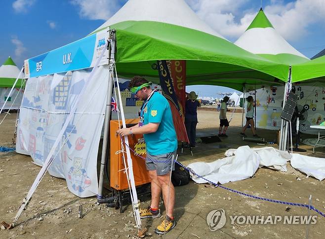 '떠날게요' (부안=연합뉴스) 이율립 기자 = 2023 세계스카우트잼버리 참가단 철수를 선언한 영국 운영요원이 5일 오전 전북 부안군 행사장 영지 내에 설치한 국가 홍보 부스를 철거하고 있다. 2023.8.5 2yulrip@yna.co.kr