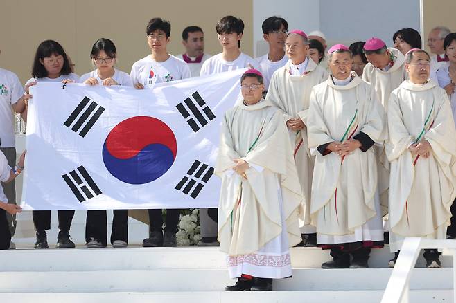 8월 6일 포르투갈 리스본에서 열린 세계청년대회 폐막 미사에서  다음 개최지가 대한미국 서울로 결정된 가운데 한국 대표단과 청년들이 태극기를 들고 무대에서 단체사진을 찍기 위해 포즈를 취하고 있다. /AFP 연합뉴스