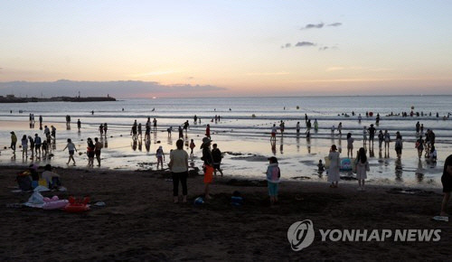 무더운 날씨를 보인 3일 제주시 삼양해수욕장에서 피서객들이 물놀이하거나 해변을 걷고 있다. [제주=연합뉴스]