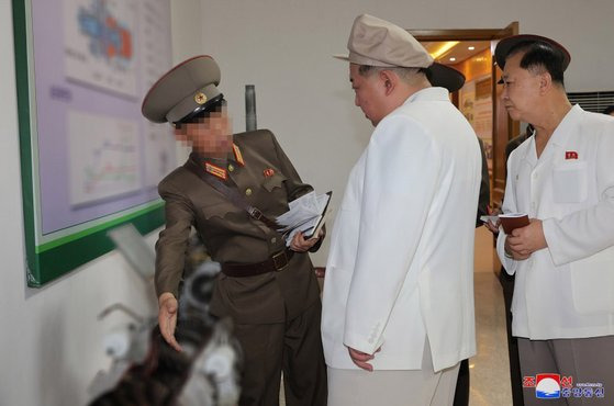 김정은 북한 국무위원장이 지난 3~5일 군수공장을 현지지도하면서 북한의 신형 무인기 엔진으로 추정되는 물체를 바라보는 모습. 조선중앙통신. 연합뉴스.