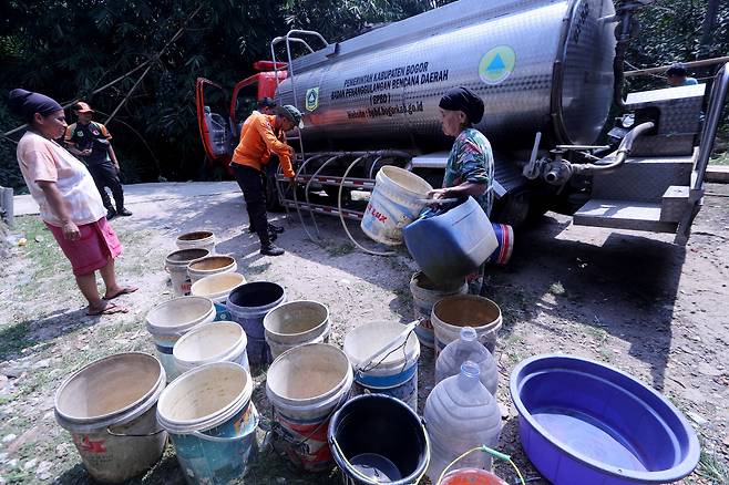 인도네시아 63%가 엘니뇨로 인해 극단적으로 건조한 날씨 영향을 받고 있는 가운데, 지난 3일 인도네시아 서부자바주 보고르의 웬닝갈리 마을에서 보고르 지방재난관리청(BPBD) 관계자들이 주민들에게 깨끗한 물을 나눠주고 있다. / EPA·연합뉴스