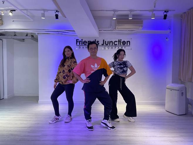 Kenny Ng Ka-wai (center), director of Friends Junction Dance Company, strikes a pose with his students at a FJDC studio in Hong Kong on March 21. (Naomi Ng/The Korea Herald)