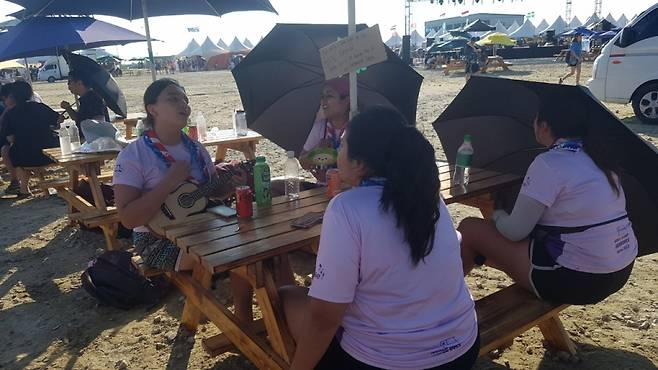 칠레 청소년 대원들이 브라질 식당 앞 테이블에서 모여 앉아 칠레 전통 현악기인 차랑고 반주에 맞춰 노래하고 있다/사진= 유동주 기자