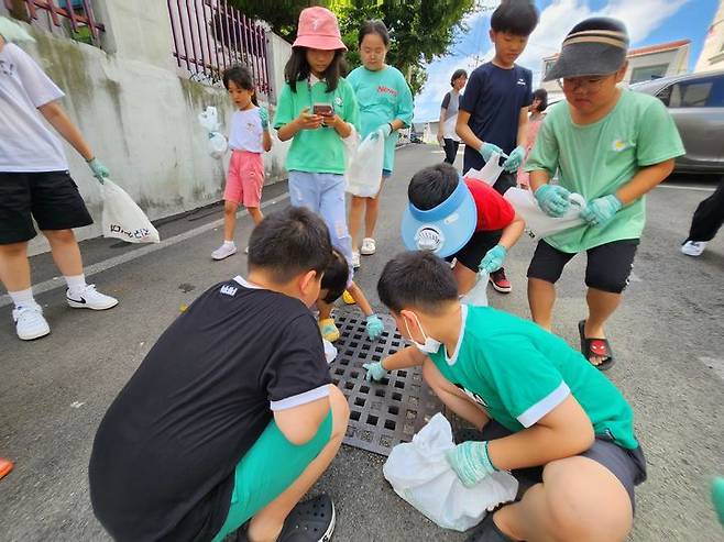 [고성(경남)=뉴시스] 신정철 기자= 경남 고성군 다함께돌봄센터 1호점(센터장 백정여)은 지난 8일 아동 15명과 함께 고성군종합사회복지관 주변에서 저탄소 생활 실천 자원봉사 플로깅(쓰레기를 줍는 운동) 활동을 진행했다.(사진=고성군 제공).2023.08.09. photo@newsis.com *재판매 및 DB 금지