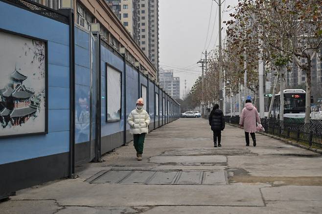 코로나19가 처음 발생한 것으로 알려진 중국 허베이성 우한시의 한 거리를 중국 시민이 걷고 있다. (사진=AFP)