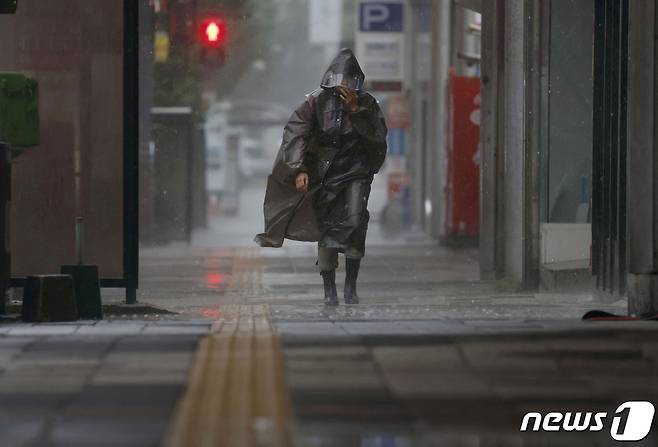 9일 (현지시간 ) 태풍 카눈 영향으로 일본 규슈의 가고시마에서 폭우와 강풍 속을 주민이 걸어 가고 있다. 2023.8.9 ⓒ 로이터=뉴스1 ⓒ News1 우동명 기자