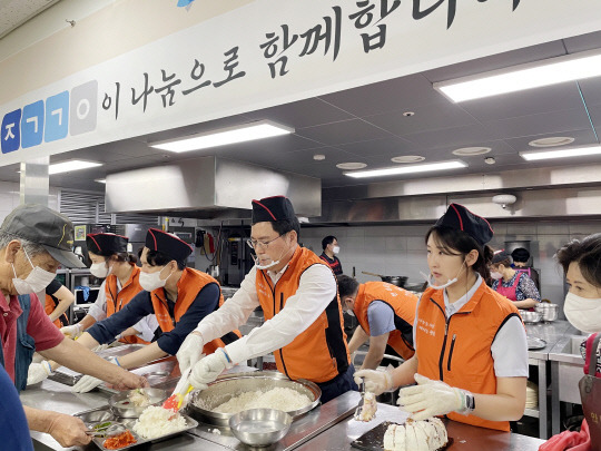 윤창호(가운데) 한국증권금융 이사장과 한마음 봉사단이 '안나의집' 무료급식소에서 배식 봉사를 진행하고 있다. 한국증권금융 제공.