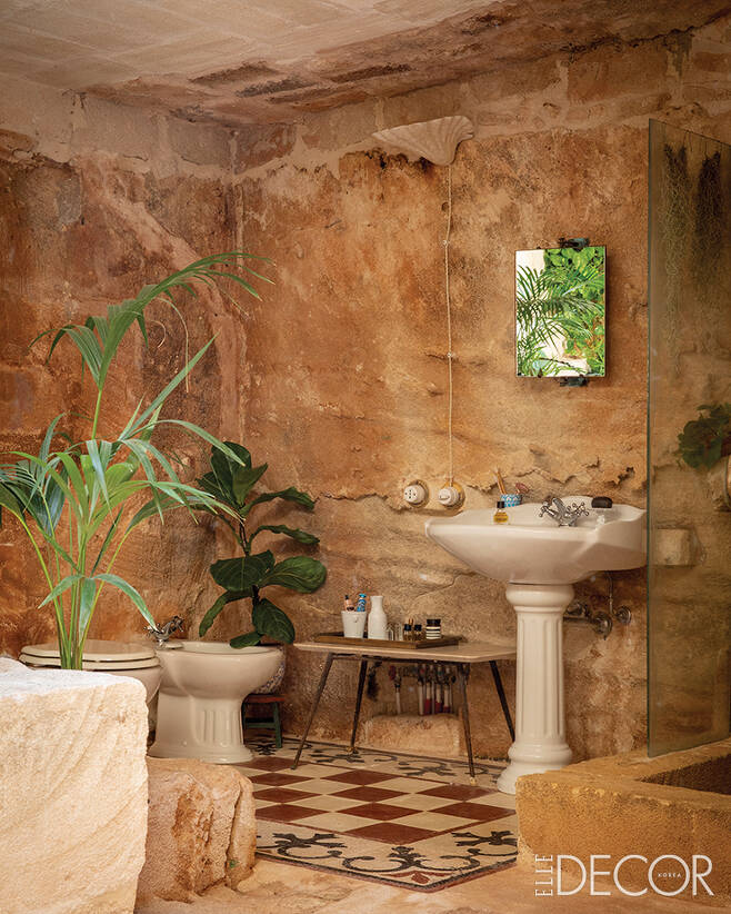 욕실 전경. 오래된 석조를 이용해 샤워 공간을 만들었다. 오래된 타일로 바닥을 마감하고 빈티지 가구를 배치했다. ㅍ