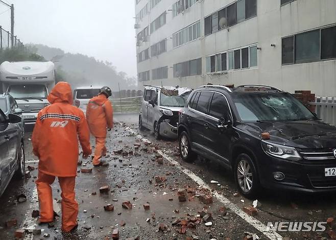 [거제=뉴시스] 홍정명 기자 10일 오전 6시19분께 경남 거제시 능포동 모 아파트 지붕구조물이 떨어져 주차 차량이 파손됐다는 신고를 받고 출동한 소방대원들이 현장 안전조치를 하고 있다.(사진=경남소방 제공) 2023.08.10. photo@newsis.com