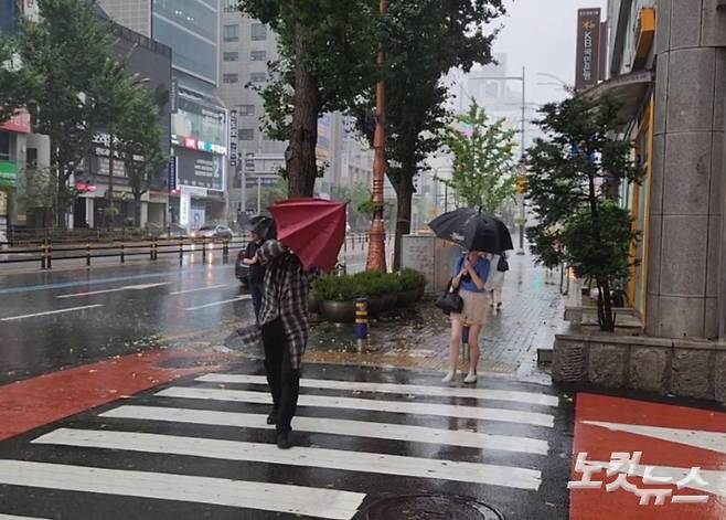 제6호 태풍 '카눈'이 상륙한 10일 오전 9시쯤 부산 연제구에서 시민들이 비바람을 맞으며 길을 걷고 있다. 정혜린 기자