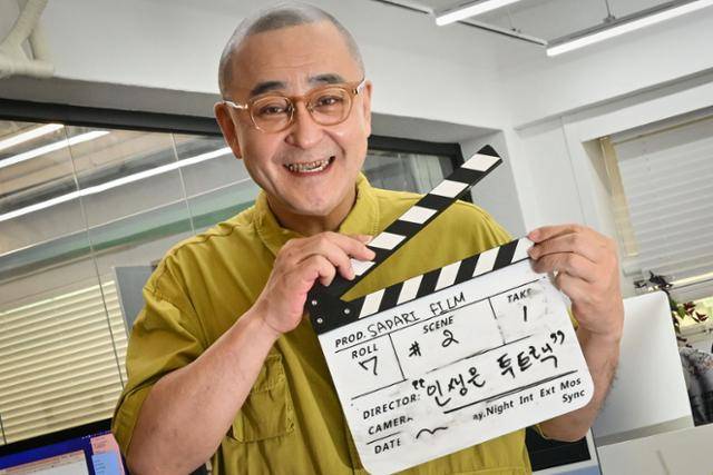 2000년대 ‘스타 영어강사’로 이름을 날린 문단열 사다리필름 대표를 1일 서울 마포구 사무실에서 만났다. 사다리필름은 그가 8년 전 만든 영상제작 업체다. 그가 자신의 인생을 스토리로 만들면 결국 투 트랙이었다는 의미로 슬레이트를 들어 보이고 있다. 최주연 기자