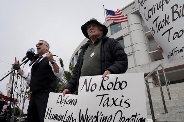 10일(현지시간) 미국 샌프란시스코 캘리포니아 공공시설위원회 앞에서 시민들이 로보택시 확대에 반대하는 시위를 하고 있다. 샌프란시스코=AP 연합뉴스