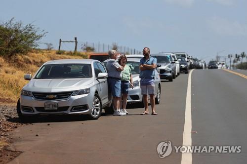 9일 하와이 마우이섬에서 산불로 도로가 통제돼 여행객들이 대기 중인 모습. [로이터=연합뉴스. 재판매 및 DB 금지]