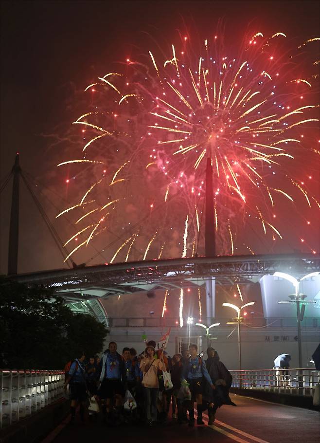 11일 서울 마포구 상암동 서울월드컵경기장에서 2023 새만금 세계스카우트 잼버리 폐영식과 K팝 슈퍼 라이브 콘서트 관람을 마친 세계스카우트 대원들이 불꽃놀이를 뒤로한 채 경기장을 나와 버스로 향하고 있다.(사진=연합뉴스)