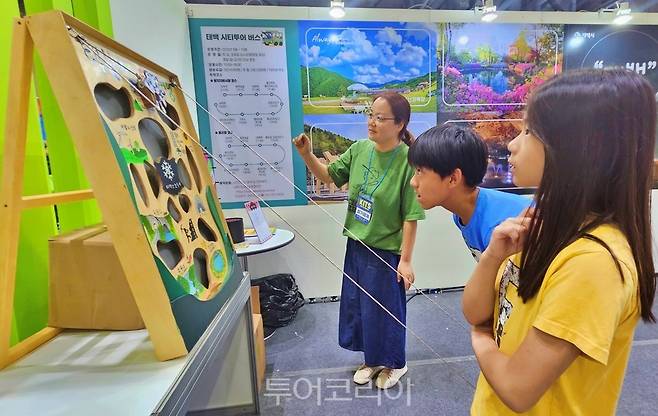 태백시 홍보부스에서 관람객이 조경희 관광정책팀장의 설명을 들으며 '태붐이와 태백여행' 체험이벤트를 즐기고 있다.