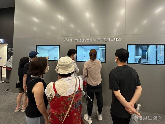 지난 11일 청계SK뷰 견본주택에서 방문객들이 VR장비를 통해 아파트 옵션을 살펴보고 있다. 신혜원 기자