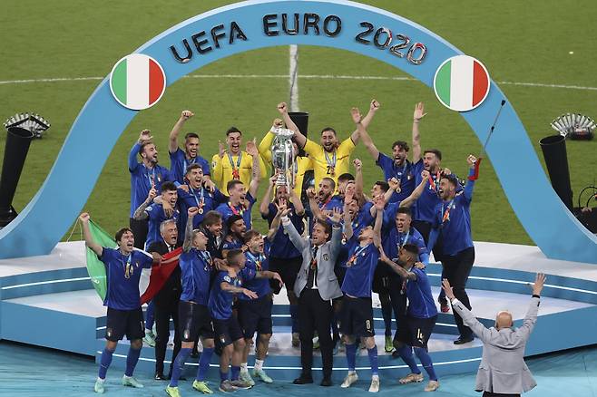 FILE - Italian team celebrates with the trophy after the Euro 2020 soccer final match between England and Italy at Wembley stadium in London, on July 11, 2021. Italy coach Roberto Mancini resigned surprisingly on Sunday, Aug. 13, 2023, ending an an up-and-down tenure with the national team that included a European Championship title in 2021 but also a failed qualification for last year's World Cup. (Catherine Ivill/Pool via AP, File) FILE PHOTO