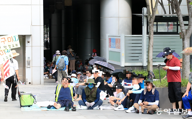 시청 건물 그늘진 부분에 시민들이 앉아있다. 사진=장승윤 기자