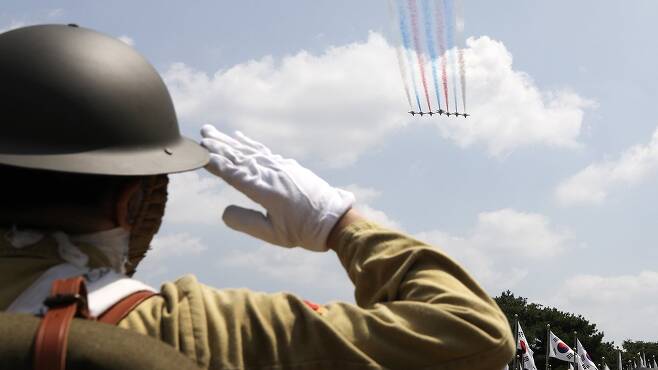 광복군 분장을 한 관람객이 충남 천안 독립기념관에서 축하비행을 펼치는 공군 특수비행팀 '블랙이글스'를 향해 경례하고 있다. 뉴스1
