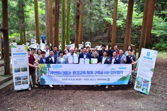 장성군 관계자들과 환경교육재단 관계자들이 축령산 편백숲에서 업무협약 후 기념사진을 찍고 있다.