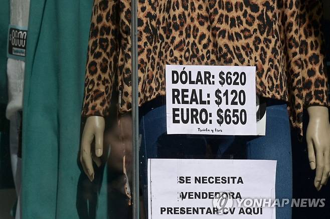 '우리는 달러당 620 아르헨티나 페소' (부에노스아이레스 AFP=연합뉴스) 14일(현지시간) 아르헨티나 부에노스아이레스 한 옷 가게 입구에 '1달러당 620 아르헨티나 페소, 브라질 1헤알당 120 아르헨티나 페소, 1유로당 650 아르헨티나 페소'의 비공식 환율을 적용한다는 의미의 종이가 붙어 있다. 2023.8.15