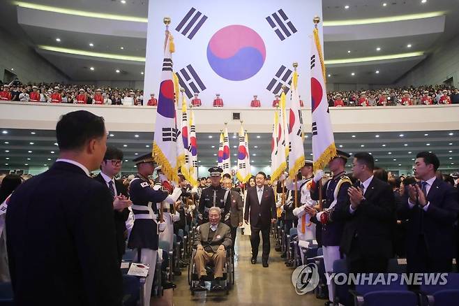 애국지사와 함께 입장하는 윤석열 대통령 (서울=연합뉴스) 진성철 기자 = 윤석열 대통령과 김건희 여사가 15일 서울 서대문구 이화여대 대강당에서 열린 제78주년 광복절 경축식에 오성규, 김영관 애국지사와 함께 입장하고 있다. 2023.8.15 [대통령실통신사진기자단] zjin@yna.co.kr