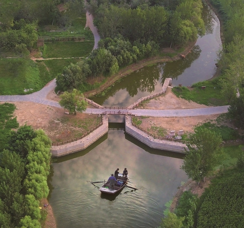 A boat is floating on the water at the lower water gate of Jingmen in Yanggu County.