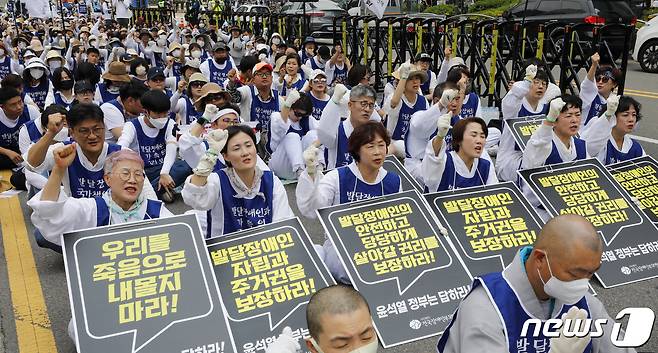 전국장애인부모연대 활동가들과 대한불교조계종 사회노동위원회 회원들이 발달장애인 전 생애 권리기반 지원체계 구축 촉구 집회에서 구호를 외치고 있다. 2023.6.14/뉴스1 ⓒ News1 김도우 기자