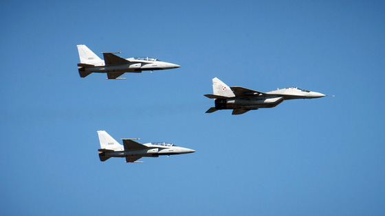 The first of two Korean FA-50 light fighter aircraft delivered to Poland fly above Warsaw in formation behind a MiG-29 fighter on Tuesday during a military parade in Warsaw to celebrate the country's Armed Forces Day. [KOREA AEROSPACE INDUSTRIES]