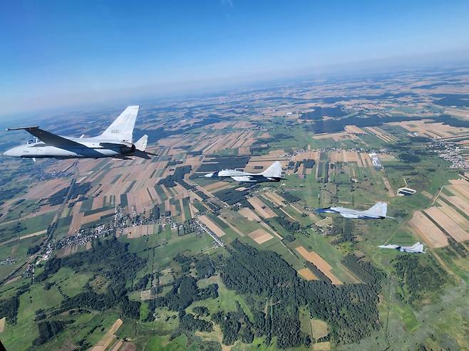 FA-50GF(첫번째)가 미그29와 함께 폴란드 바르샤바 상공을 비행하고 있다.[KAI 제공]